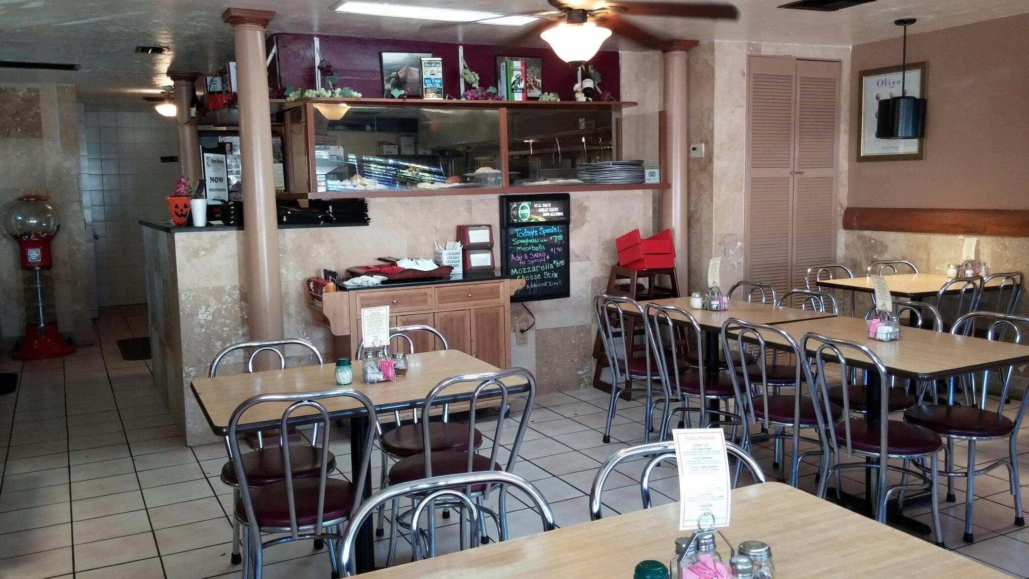 Inside San Remo Pizza & Pasta's dining room on Tamiami Trail, chalkboard specials on the wall